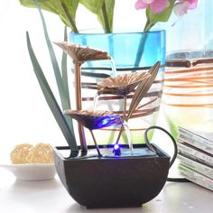 a vase filled with flowers sitting on top of a table next to books and magazines