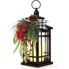 a christmas lantern with holly and pine cones