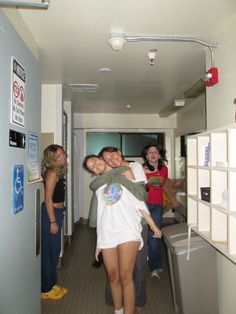 a group of people standing around each other in a hallway