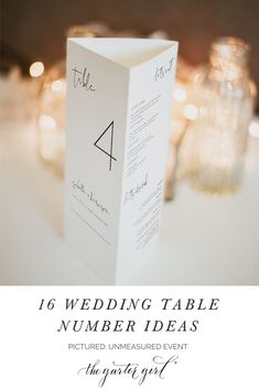 a table with candles and cards on it that says, 16 wedding table number ideas