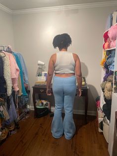 a woman standing in front of a closet full of clothes