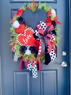 a heart shaped wreath is hanging on the front door