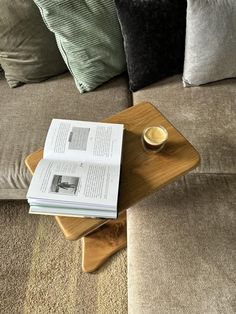 a wooden table topped with an open book on top of a couch