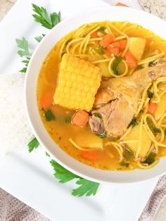 a bowl of chicken soup with corn on the cob