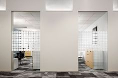 an office cubicle with white walls and black checkered flooring, mirrors on the wall