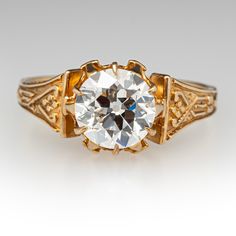 This marvelous circa 1900 ring is centered with one (1) old European cut diamond weighing 1.33 carats that is set into a six-prong setting. Engraved detail accented the shoulders of the ring. The ring measures 8.5mm at the top, rises 7.0mm above the finger, tapering to 1.8mm wide and 0.9mm thick at the base of the shank. It is currently a size 6.5. Luxury Yellow Gold Victorian Engraved Ring, European Cut Diamonds, Diamond Engagement Ring, Prong Setting, Diamond Engagement, Diamond Cuts, Yellow Gold, Size 6, Ring