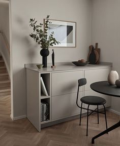 a dining room table with two chairs and a vase on it