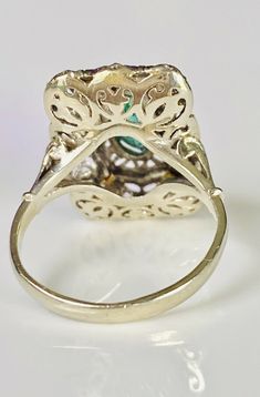 Beautiful vintage 18K yellow and white gold emerald ring. The openwork filigree work white gold setting has a lovely gold detail surrounding a pronged marquise cut emerald (approx. 9.9mm x 5.7mm). The ring measures approx. 19.2mm from north to south and 13mm from east to west. The ring is currently sized at 6.5 and marked 18k. 5.3 grams total weight. Elegant Yellow Gold Emerald Ring With Intricate Design, Fine Jewelry Emerald Ring With Intricate Design, Vintage White Gold Emerald Jewelry, Oval Filigree Ring With 17 Jewels For Anniversary, Emerald Ring With Intricate Design, Formal Emerald Ring With Intricate Design, Heirloom Emerald Ring With Intricate Design, Collectible Art Deco Emerald Ring, Elegant Collectible Emerald Ring With Prong Setting