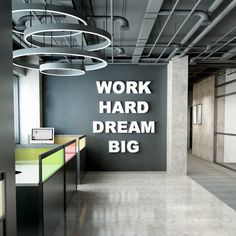 an office with black walls and white lettering on the wall that says work hard, dream big