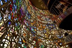 a man standing in front of a very large stained glass window on the side of a building