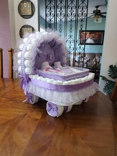 a baby carriage cake sitting on top of a wooden table