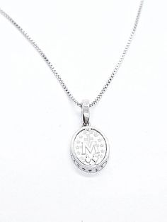 Miraculous Medal In Sterling Silver 925 set with Cubic Zirconia on Silver Chain. Medal size: 15mm Chain length:44cm/17.32 inch Diamond White Sterling Silver Initial Pendant Jewelry, Diamond White Sterling Silver Jewelry With Initial Pendant, Silver Initial Pendant With Diamond Cut, Engraved Sterling Silver Necklace In Diamond White, Engraved White Gold Necklace With Cubic Zirconia, White Gold Sterling Silver Necklace With Oval Pendant, Engraved Cubic Zirconia Pendant Necklace, Sterling Silver Oval Necklace With Diamond Cut, White Gold Medallion Necklace With Sterling Silver Clasp