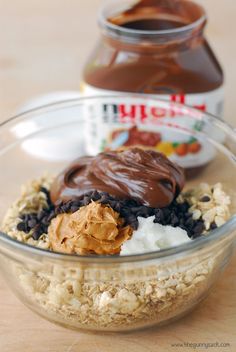 a bowl filled with peanut butter, chocolate and oatmeal next to a jar of nutella