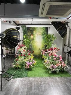 a photo studio set up with flowers and umbrellas in front of the camera's backdrop