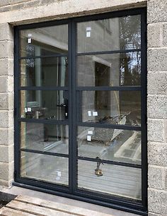 an open window on the side of a brick building with glass panes in front of it