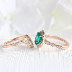 This large oval emerald ring bridal set features a vintage-inspired emerald engagement ring set in a 14k rose gold vintage floral halo diamond ring setting. To complete the unique vintage style look, a large 7 diamond U-shaped scalloped wedding band is created to pair with this oval emerald diamond ring. Celebrate your love with this beautiful earthy green engagement ring set! It can be crafted in your choice of platinum, or 18k or 14k yellow, rose, or white gold. ** The hand model's ring size i Elegant Emerald Stackable Wedding Rings, Emerald Gemstone Stackable Wedding Rings, Heirloom Marquise Cut Emerald Wedding Ring, Stackable Oval Emerald Wedding Ring, Oval Stackable Emerald Wedding Ring, Emerald Cut Stackable Emerald Rings For Wedding, Wedding Stackable Emerald Rings With Emerald Cut, Emerald Cut Gemstone Stackable Wedding Rings, Emerald Stackable Rings For May Birthstone Wedding