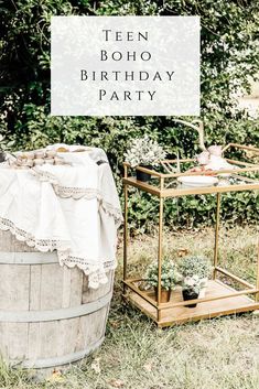 a birthday party with an old wooden barrel and potted plants on the side, surrounded by greenery