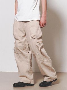 This is a comfortable cargo pants that is made out of sturdy cotton 100% fabric. With a unique cut pattern and wide adjustable silhouette with snaps on the hem, you can wear it for casual and daily outfit. - YKK zipper closure- Adjustable YKK snaps on the hem- Leather logo label detail- Wide silhouette Khaki Wide-leg Cargo Jeans, Techwear Cotton Cargo Pants With Flap Pockets, Baggy Khaki Cotton Cargo Jeans, Beige Cotton Cargo Jeans With Patch Pockets, Beige Straight Leg Cargo Jeans For Streetwear, Beige Cotton Cargo Jeans, Khaki Cotton Techwear Cargo Pants, Baggy Khaki Cargo Pants With Cargo Pockets, Khaki Cotton Parachute Pants With Flap Pockets