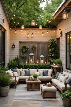 an outdoor living area with couches, tables and potted plants