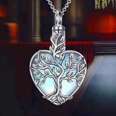 The Tree of Life symbolizes immortality and reincarnation, representing eternal life. This heart-shaped urn necklace combines the mystical allure of moonstone, offering an elegant and meaningful way to keep a loved one close to your heart. Intended Use The necklace is designed to securely hold a small amount of ashes through a top screw closure. If preferred, it can also contain perfume, crushed flowers, dirt, hair, sand, or a note, providing a versatile option for remembrance. Material Crafted Spiritual Heart Charm Jewelry For Memorial, Spiritual Jewelry With Heart Charm For Memorial, Spiritual Heart Pendant Jewelry For Memorial, Spiritual Heart-shaped Memorial Jewelry, Memorial Heart-shaped Spiritual Jewelry, Spiritual Locket Necklace For Memorials, Silver Heart Moonstone Necklace, Silver Heart-shaped Moonstone Necklace, Spiritual Necklace With Heart Charm For Memorial