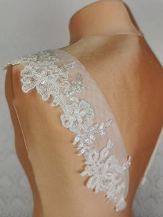 the back of a woman's dress with white lace on it