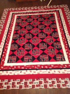 a red and black quilt is laying on the floor