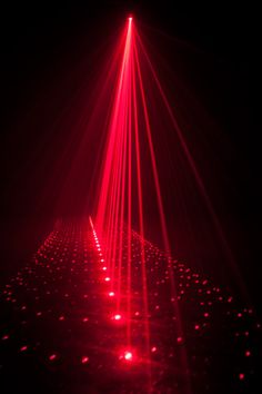 a red light shines brightly in the dark, with small dots on the floor