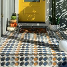 a yellow door and some potted plants on a porch