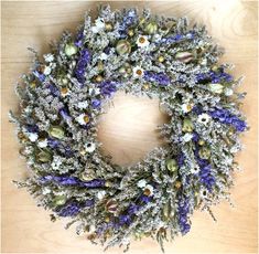 a wreath made out of dried flowers sitting on top of a wooden table