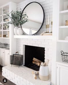 a living room filled with furniture and a fire place in front of a white brick fireplace