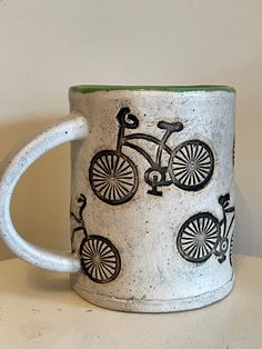 a ceramic coffee mug with bicycles painted on it