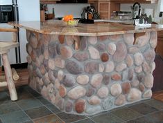 an island made out of rocks in a kitchen