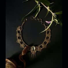 This statement piece rings with mystery and glamor.  This amulet is made from the skin shed of our sweet and pampered ball python, Tutu.  When a snake sheds her skin, it’s a powerful reminder that we have the ability to change old patterns and create a new version of ourselves. A piece of Tutu’s shed resides under glass and is set on top of a colored paper to bring out the beautiful texture of her scales. This pendant features a Tutu-shed centerpiece surrounded by 12 labradorite cabochons on fil Spiritual Snake-shaped Metal Jewelry, Engraved Metal Snake-shaped Jewelry, Luxury Collectible Bronze Jewelry, Elegant Handmade Snake-shaped Jewelry, Luxury Bronze Metal Jewelry, Handmade Snake-shaped Brass Jewelry, Handmade Brass Snake-shaped Jewelry, Handmade Brass Snake Jewelry, Handmade Brass Snake Shaped Jewelry