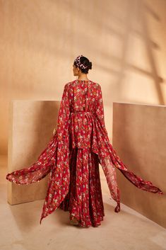 Featuring a floral-printed kaftan and sharara. The kaftan’s neckline is embroidered by hand using a mirror, sequences, and beadwork. The tie-up is accentuated with mirrors and the kaftan hem is accentuated with antique gold coins.From Aneesh Agarwaal's Seher collection.DELIVERY TIMEPlease allow 8-12 weeks for your outfit to arrive.FABRIC DETAILSChinonProfessional cleaning only. Bohemian Silk Sets With Cape Sleeves, Bohemian Sets With Dupatta And Cape Sleeves, Bohemian Silk Sharara With Printed Motifs, Red Silk Palazzo Set With Mirror Work, Traditional Drape Palazzo Set With Printed Motifs For Reception, Reception Palazzo Set With Traditional Drape And Printed Motifs, Bohemian Georgette Palazzo Set With Floral Print, Bohemian Silk Sharara With Floral Print, Red Georgette Sharara With Printed Motifs