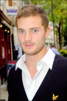 a man with blue eyes is standing on the street