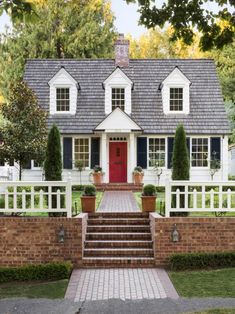 a white house with red door and steps leading up to it