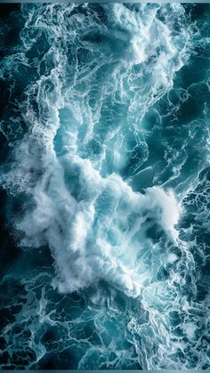 an aerial view of the ocean with waves and foamy blue water in the foreground