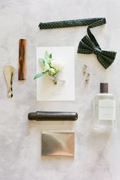 an assortment of items laid out on top of a white surface with black and silver accessories