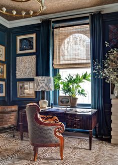 an image of a living room with blue walls and pictures on the wall above it