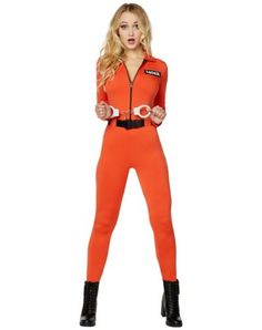 a woman in an orange jumpsuit and black boots is standing with her hands on her hips