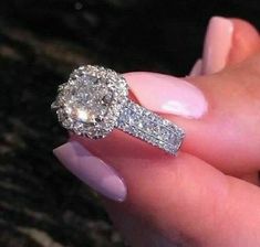 a woman's hand holding an engagement ring with two diamonds on the top and bottom