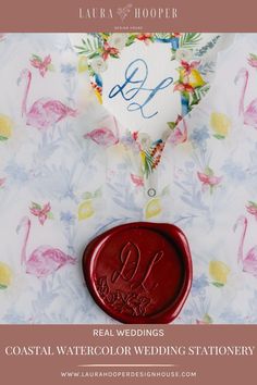 a red wax stamp sitting on top of a white shirt with flamingos around it