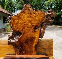 a piece of wood sitting on top of a wooden bench in front of a house