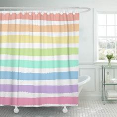 a bathroom with a bathtub, sink and shower curtain in rainbow - colored stripes