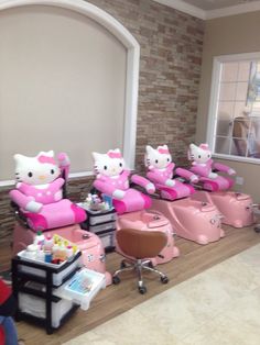 the children are sitting in their pink hair salon chairs with hello kitty cushions on them