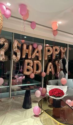 a room filled with balloons and pink flowers