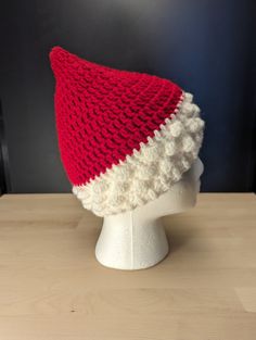 a red and white knitted hat sitting on top of a head