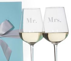 two wine glasses with the word mr and mrs written on them next to a blue gift box