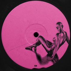 a pink disc with a drawing of a woman sitting on the floor in front of it