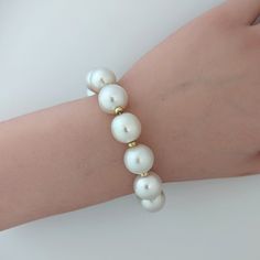 Introducing a top-notch White South Sea pearl bracelet, beautifully embellished with 14K yellow gold donut rondelles and fastened with a 14K yellow gold interlocking oval clasp. The pearls mesmerize with their 100% natural color – a radiant white with a soft pink overtone. The pearls are semi-baroque in shape and their sizes vary from 12 to 14 mm. 14k yellow gold rondelles are 4mm. The high luster of the pearls is sure to captivate anyone's attention. With a length of 9" (22cm), this bracelet be Elegant Formal Baroque Pearl Bracelets, Elegant Formal Baroque Pearl Bracelet, Luxury Pearl Bracelet With Round Beads And Charm, White Baroque Pearl Bracelets For Formal Occasions, Luxury Baroque Pearl Bracelet For Formal Occasions, Formal White Baroque Pearl Bracelets, Luxury Pearl White Bracelet With Pearl Drop, Luxury Pearl White Beaded Bracelets, Luxury Baroque Pearl Bracelet In Pearl White